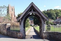 The lych gate of St George priory church in Dunster, Somerset. It marks the start of consecrated ground and traditionally pall bearers would lay the coffin here and the priest would start the service