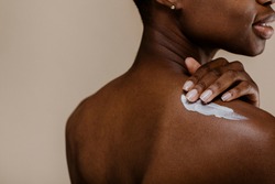 Black woman applying body cream