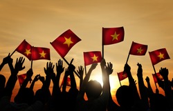 Group of People Waving Vietnamese Flags in Back Lit