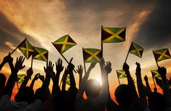 Group of People Waving Flag of Jamaica in Back Lit