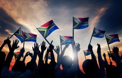 Group of People Waving South African Flags in Back Lit