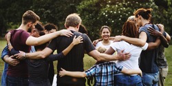 Group of people huddle together in the park