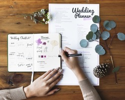 Hands Checking on Wedding Planner Notebook