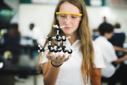 High school student hand holding molecule structure in chemistry class