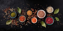 Legumes panorama, shot from the top on a black background. Lentils, soybeans, chickpeas, red kidney beans, a vatiety of pulses