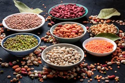 Legumes assortment on a black background. Lentils, soybeans, chickpeas, red kidney beans, a vatiety of pulses