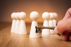 Unlock potential - motivational concept. Manager (HR specialist) unlock leader potential represented by figurine and hand with key.