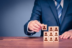 Human resources, social networking, assessment center concept, personal audit or CRM concept - recruiter complete team by one person. Employees are represented by wooden cubes with icons.