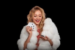 Happy girl playing cards. Lucky Girl with curly hairstyle and perfect make-up is posing with casino chips in her hands. Gambling, successful rye-haired Woman               