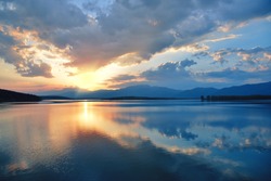Beautiful Sunset.Sun,lake.Sunrise Landscape.Beauty in Nature.Blue Sky. Amazing Colorful Clouds.Water Reflections.Magic Artistic Wallpaper.Creative Orange Background.Tranquil Natural Art Photography.
