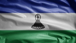 Lesotho flag waving in the wind. Close up of Sesotho banner blowing, soft and smooth silk. Cloth fabric texture ensign background.