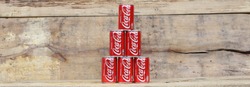 AMELAND DUTCH - 17 APRIL 2017.: COCA COLA. Coca Cola can drinks on wooden background., The carbonated soft drink is produced by The Coca-Cola Company.