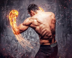 Shirtless aggressive fighter with burning boxer gloves on grey background.