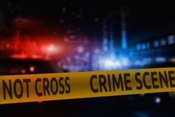 Crime scene tape on the background of night city lights and flashing lights of police cars