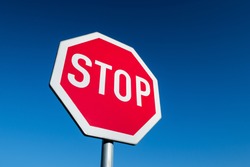 Stop sign in perspective view against blue sky