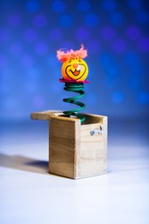 Little clown ping pong welcome surprise from wood box with blue blurry circle background