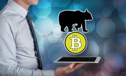Bitcoin bearish trend concept above a tablet held by a man