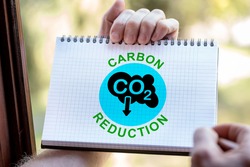 Hand drawing carbon reduction concept on a notepad