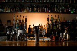 beautiful view of composition with different bar equipment and steel tools which stand on bar counter. Blurred bar background