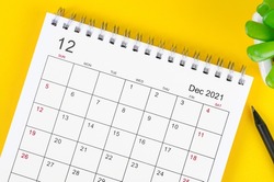 Close up December 2021 desk calendar on yellow background.