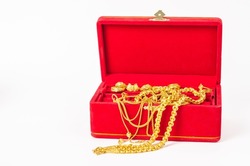 Group of gold necklace and gold ring of accessories in red box on white background.