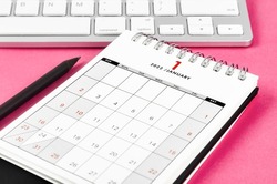 The January 2022 desk calendar with pencil on pink background.