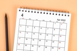 Close up April 2022 desk calendar with wooden pencil.