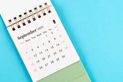 The September desk calendar 2022 on blue background.