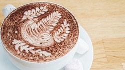 Large Hot Chocolate on a Cafe Table with Fern Decorations, Selective Focus from Above