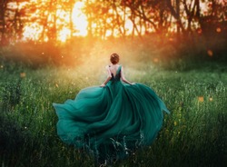 young beauty woman queen red hair runs dark mysterious forest lady long elegant royal emerald dress flying train spring tree grass sunset art photo bare open back no face turned away clothes costume