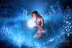 Artwork Fantasy young beautiful woman holds magical ball planet. night nature dark forest. Mystic moon light magic universe outer space. Backdrop Fairy flying bright sparkle stars white fog blue grass