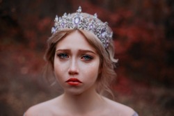Сlose-up emotional portrait of beautiful sad girl princess crying. Fairy woman medieval queen. Wet red eyes, tears streaming down her cheeks on attractive face. Vintage crown tiara on head blonde hair