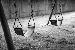 empty swings in black and white remind of childhood memories
