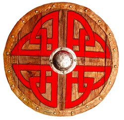 Viking round wooden brown shield decorated with a rough red-black pattern and metallic and copper protective elements