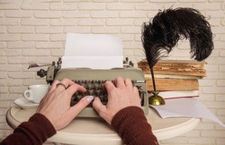 Author's woman hands typing something on an old mechanical typewriter