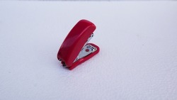 red stapler on a white background.

