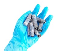Bunch of heavily corroded AA type batteries isolated in hand isolated on white background. Toxic hazards of battery disposal.