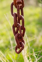 Old and rusty thick chain made of iron. Chain attached to the rear of the tractor.