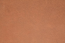 Terraсotta wall texture, background. Decor of brown textured coating. Structural plaster, rough, uneven surface in light-brown color. Modern exterior cladding of multi-story buildings