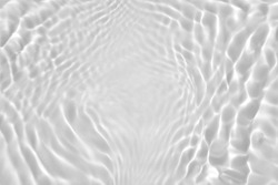 De-focused. Transparent clear calm water surface texture desaturated gray colored with splashes and bubbles. Trendy abstract nature background. Water waves in sunlight. Copy space for product mockup