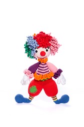 Amigurumi doll is a colorful clown standing on a white background