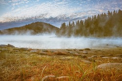 Morning misty fog at the lake, mountains pine tree forest landscape, Shiroka polyana reservoir dam, Bulgaria