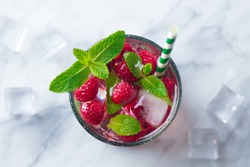 Raspberry cocktail, fizz, lemonade, ice tea with fresh mint on marble background. Top view. Copy space.