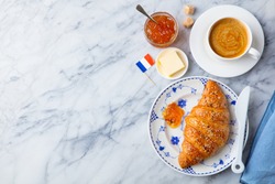 Croissant with coffee, jam, butter and French flag. Continental breakfast concept. Copy space. Top view.