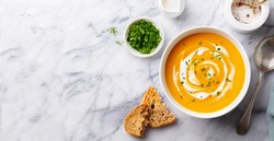 Pumpkin traditional soup with creamy silky texture. Marble background. Copy space. Top view.