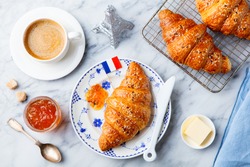 Croissant with coffee, jam, butter and French flag. Continental breakfast concept. Top view.