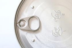 A stay tab or stay-on-tab mechanism fixed on the cover of a can to help easily unseal or open the container. A pop or pull tab on a sealed can of powdered milk. Closeup top view.