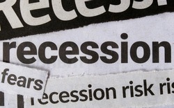 Economic recession dominating headline business news in major newspapers. Clippings of newspaper headline titles reporting on economic recession. Closeup macro view.