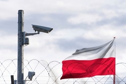 Poland flag behind of barbed wire and surveillance camera