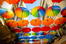 Multicolored umbrellas hanging above street in Istanbul in  sunny day and blue sky